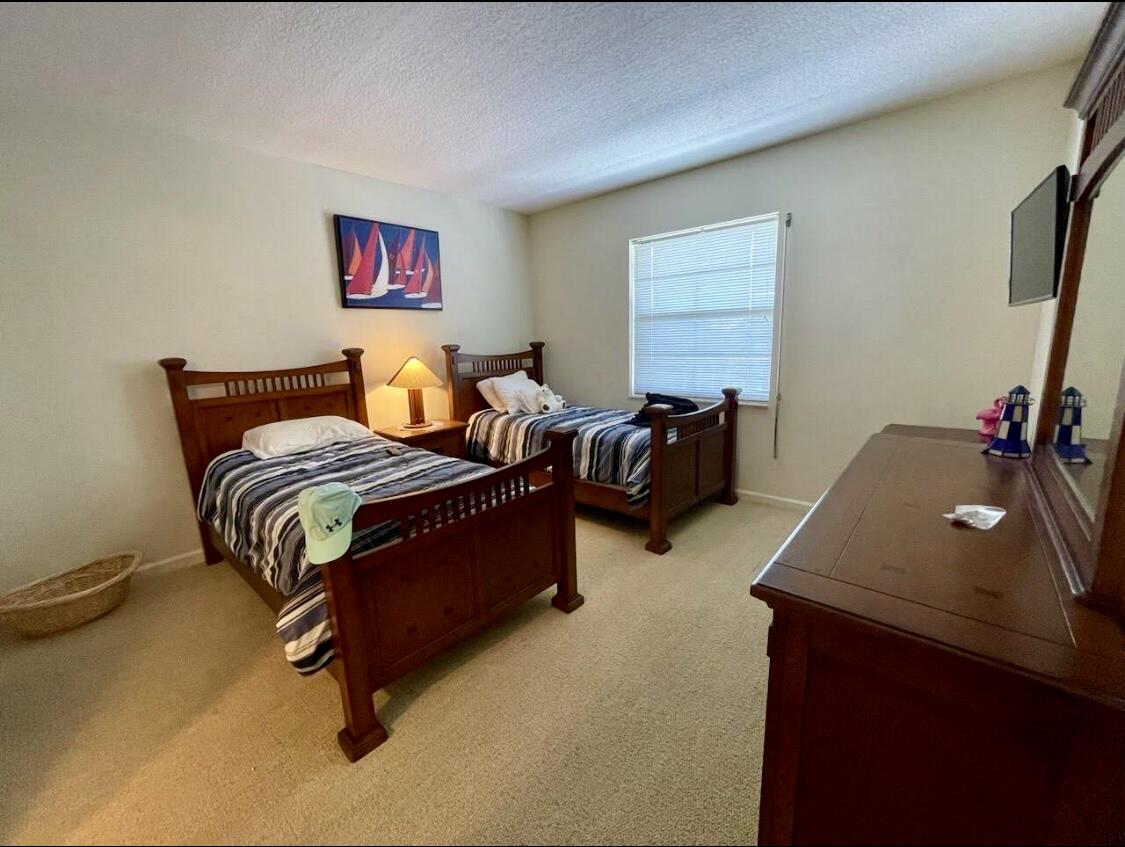 300 North Hwy A1A, Unit 405M Jupiter, FL 33477 - Photo 8 of 11 a bedroom with furniture and a bed