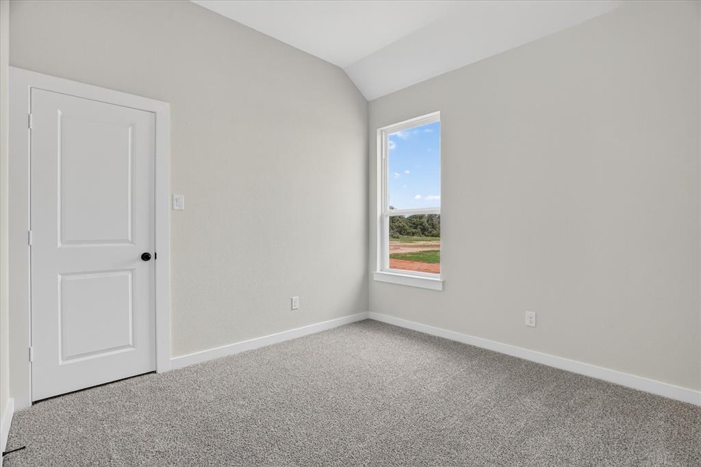 317 Skeen Peak Springtown, TX 76082 - Photo 17 of 31 Secondary bedroom with light gray walls, white trim, and gray speckled carpeting
