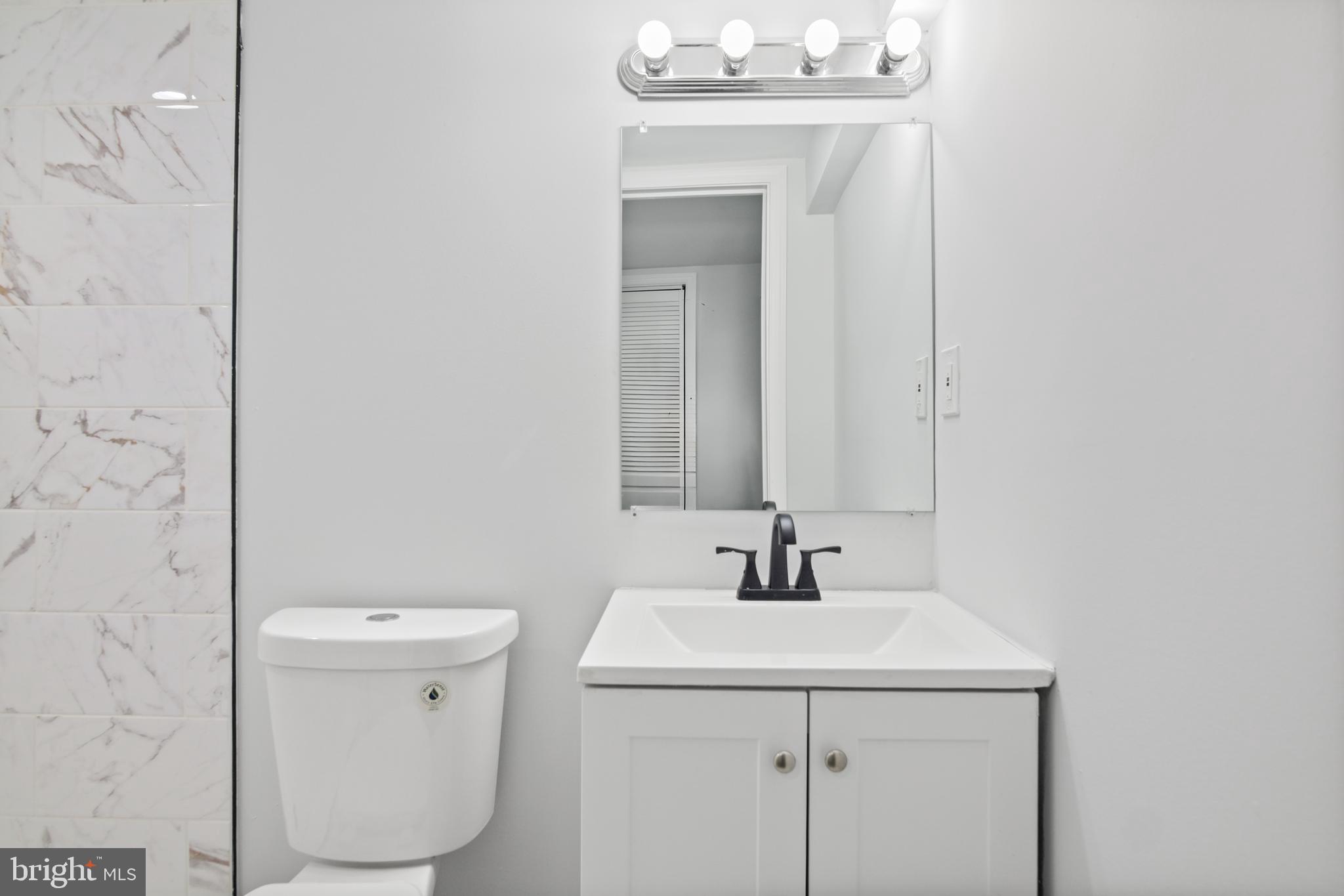 7841 Charlesmont Road Baltimore, MD 21222 - Photo 25 of 43 a bathroom with a sink mirror and toilet