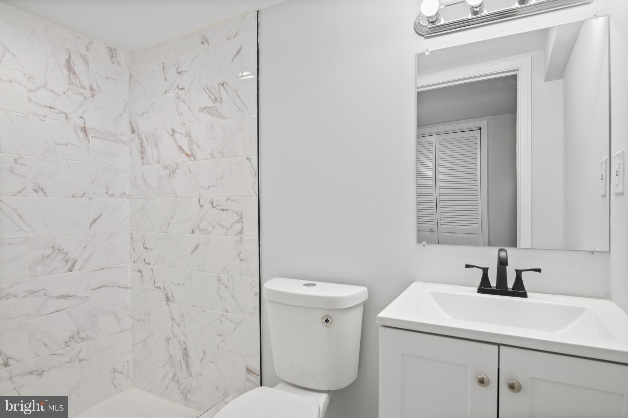 7841 Charlesmont Road Baltimore, MD 21222 - Photo 26 of 43 a bathroom with a sink a toilet and a mirror