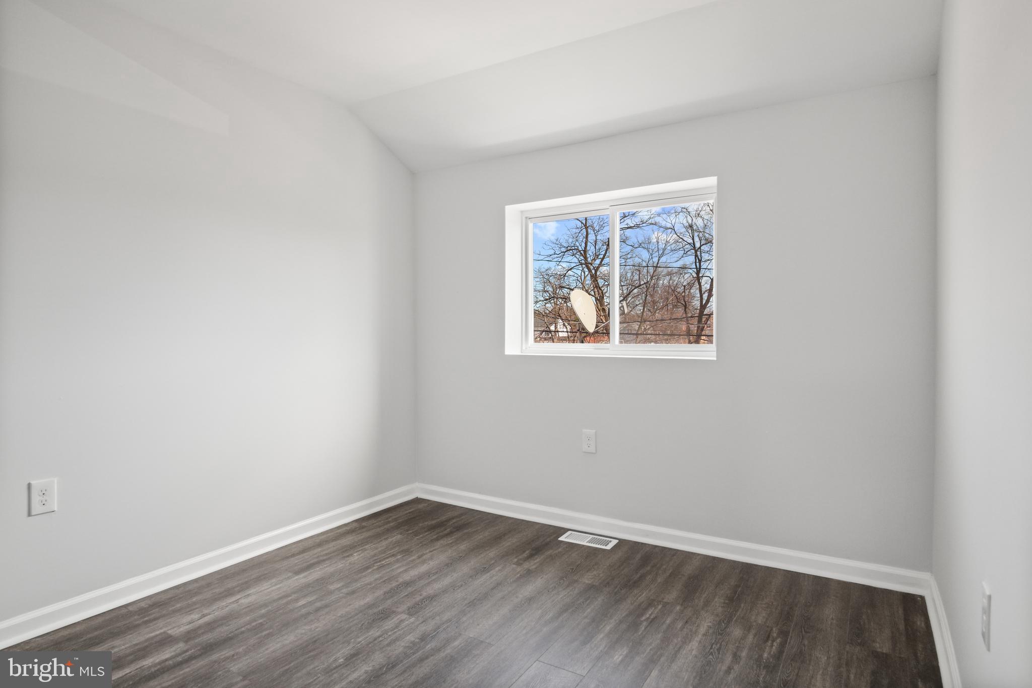 7841 Charlesmont Road Baltimore, MD 21222 - Photo 32 of 43 a view of an empty room with wooden floor and a window