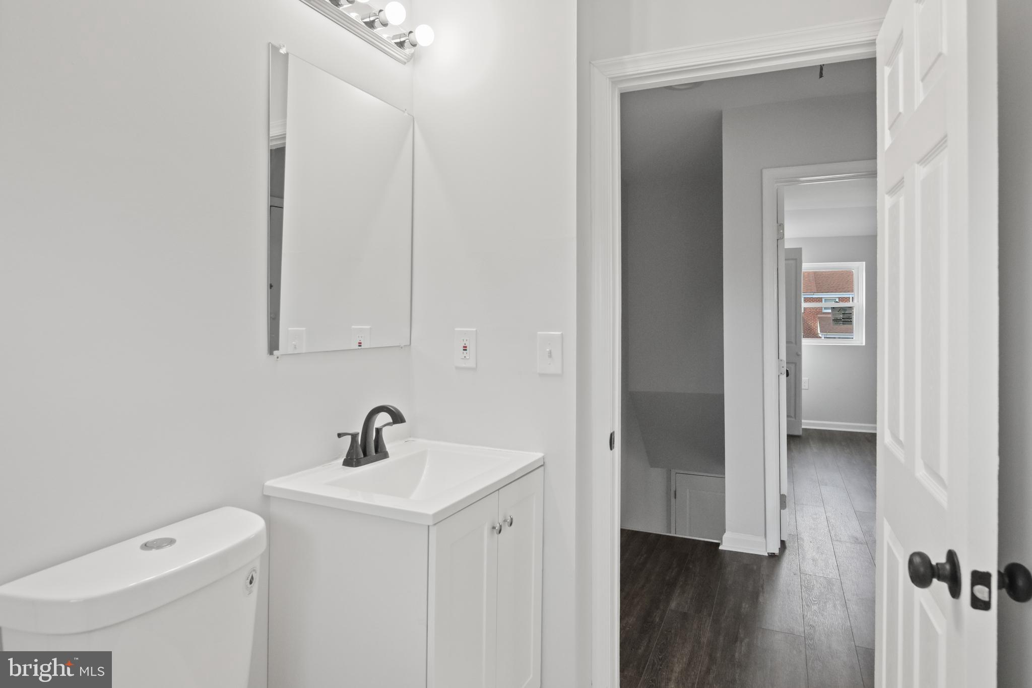 7841 Charlesmont Road Baltimore, MD 21222 - Photo 36 of 43 a bathroom with a toilet a sink and mirror