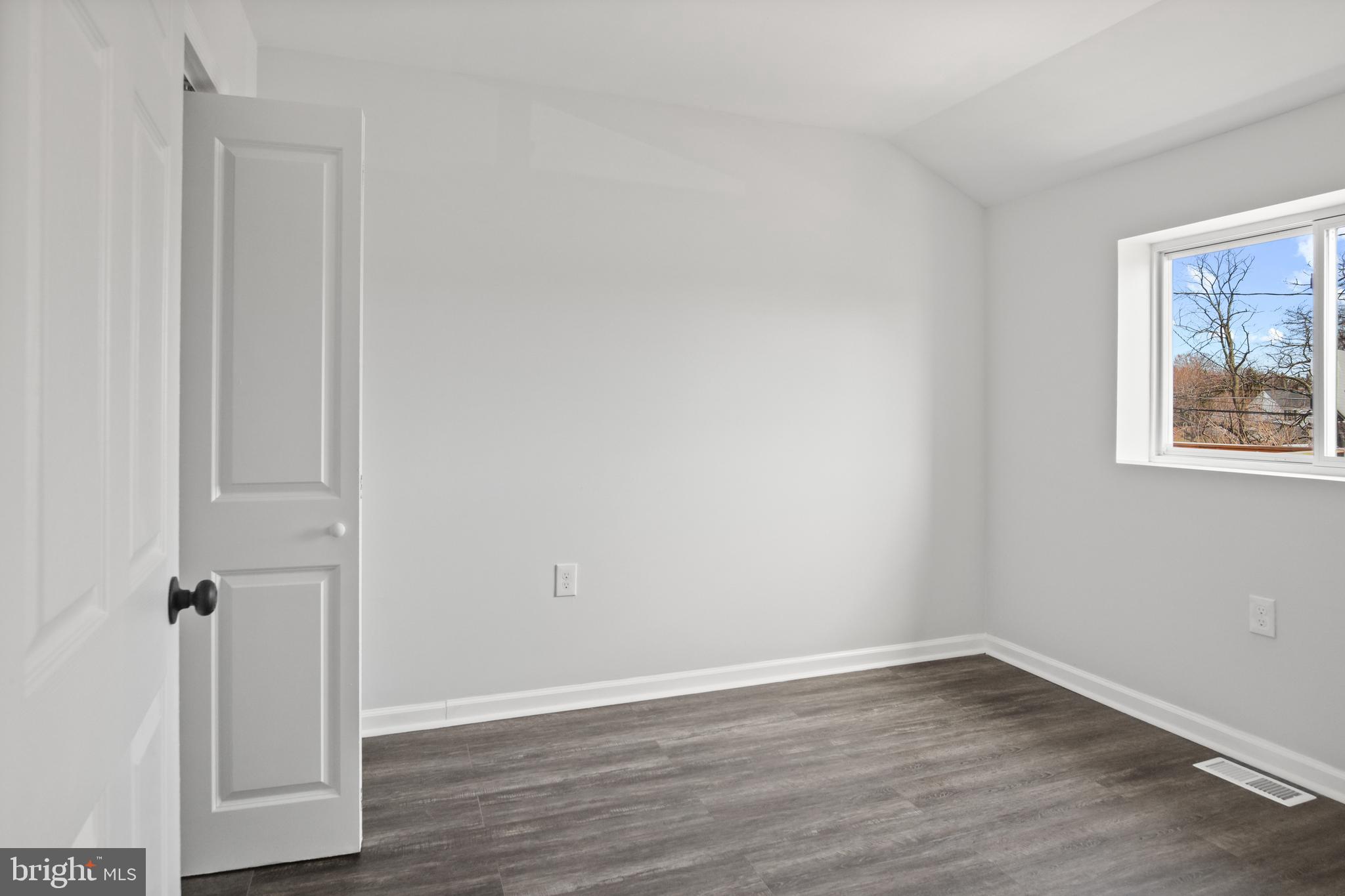 7841 Charlesmont Road Baltimore, MD 21222 - Photo 38 of 43 a view of an empty room with wooden floor and a window