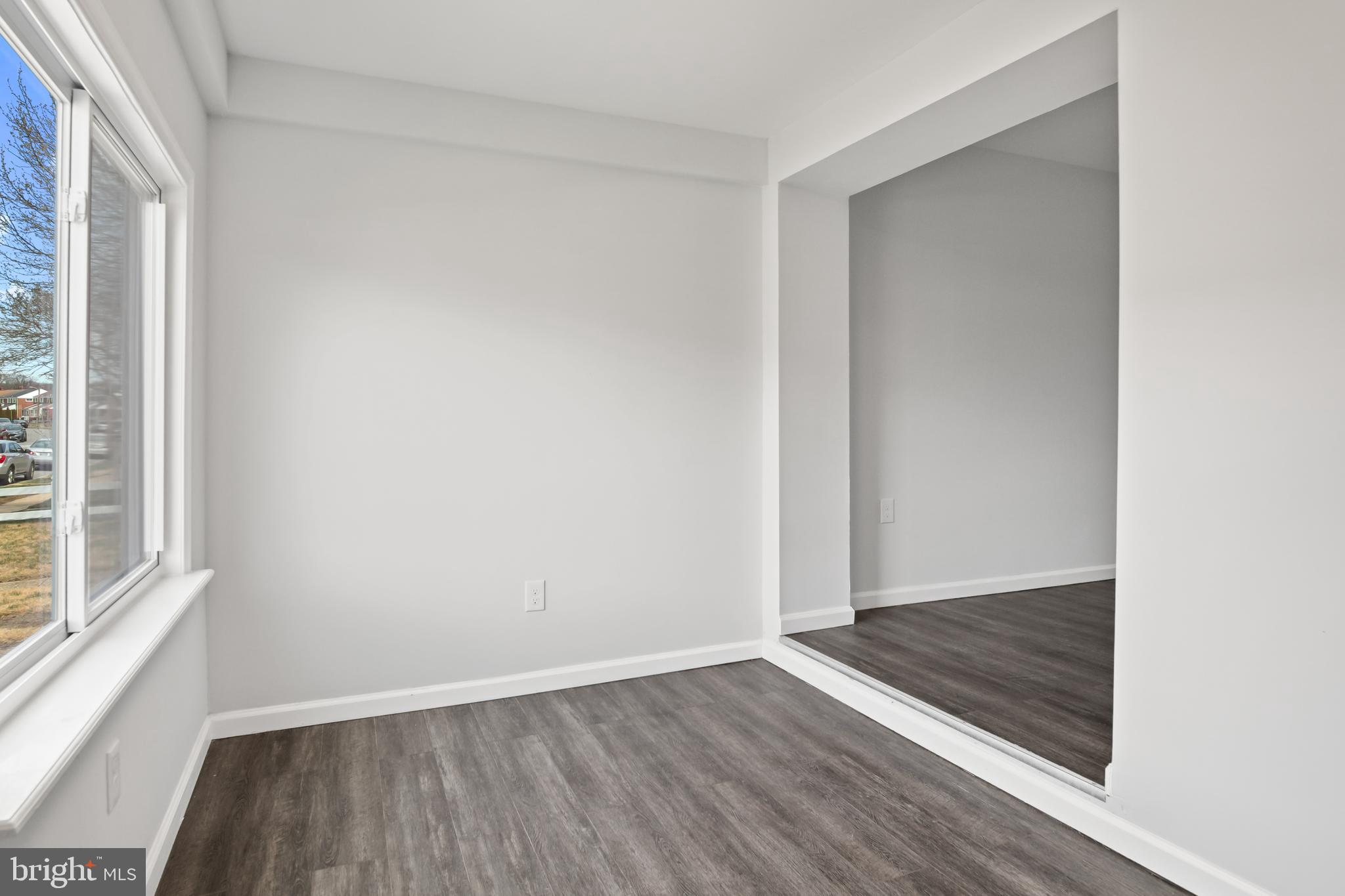 7841 Charlesmont Road Baltimore, MD 21222 - Photo 4 of 43 an empty room with wooden floor and windows