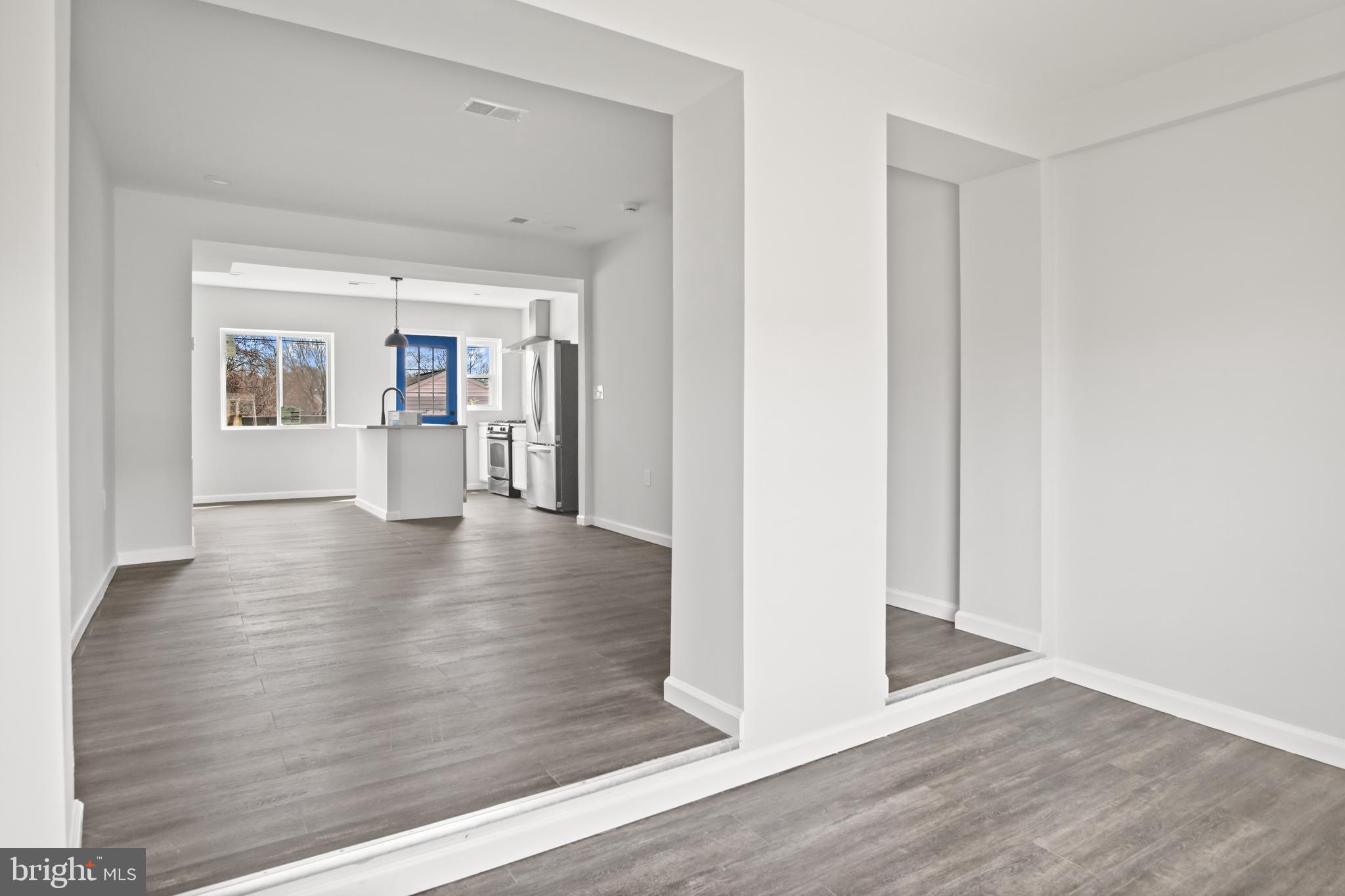 7841 Charlesmont Road Baltimore, MD 21222 - Photo 6 of 43 a view of an empty room with wooden floor and a window