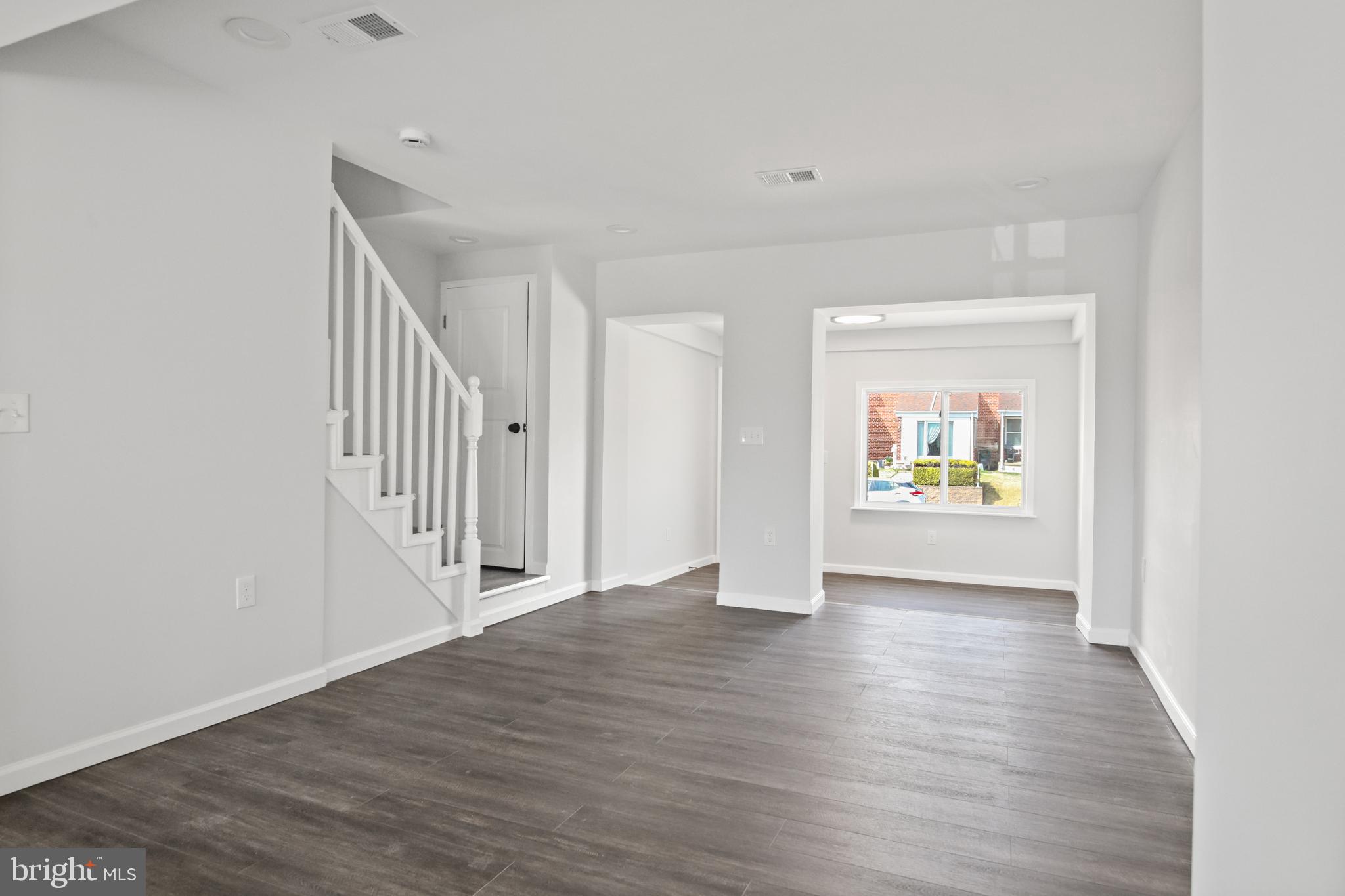 7841 Charlesmont Road Baltimore, MD 21222 - Photo 10 of 43 a view of an empty room with wooden floor and a window