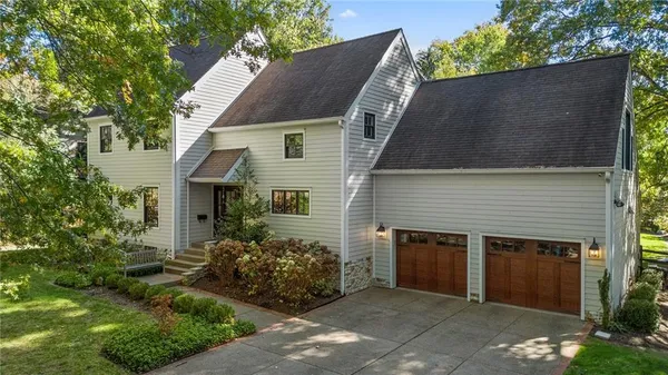 a front view of house with yard and trees in the background