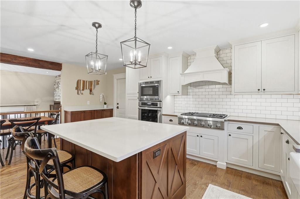 411 Woodland Road Sewickley, PA 15143 - Photo 16 of 46 a kitchen with stainless steel appliances a stove a sink a dining table and chairs