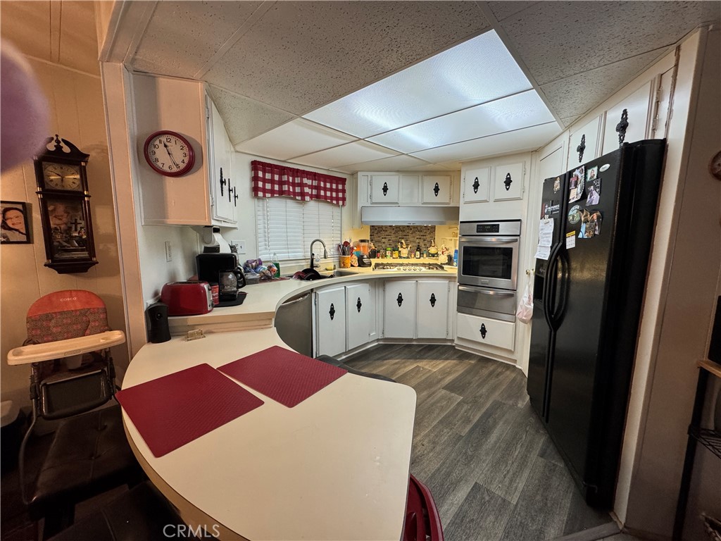 20683 Waalew Road, Unit B79 Apple Valley, CA 92307 - Photo 12 of 23 a open kitchen with stainless steel appliances granite countertop a sink refrigerator stove and microwave