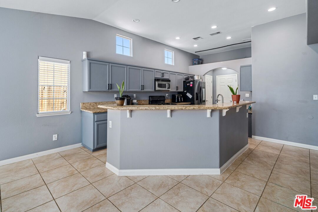 9516 Mendiburu Road California City, CA 93505 - Photo 11 of 32 a view of a kitchen with fridge and workspace