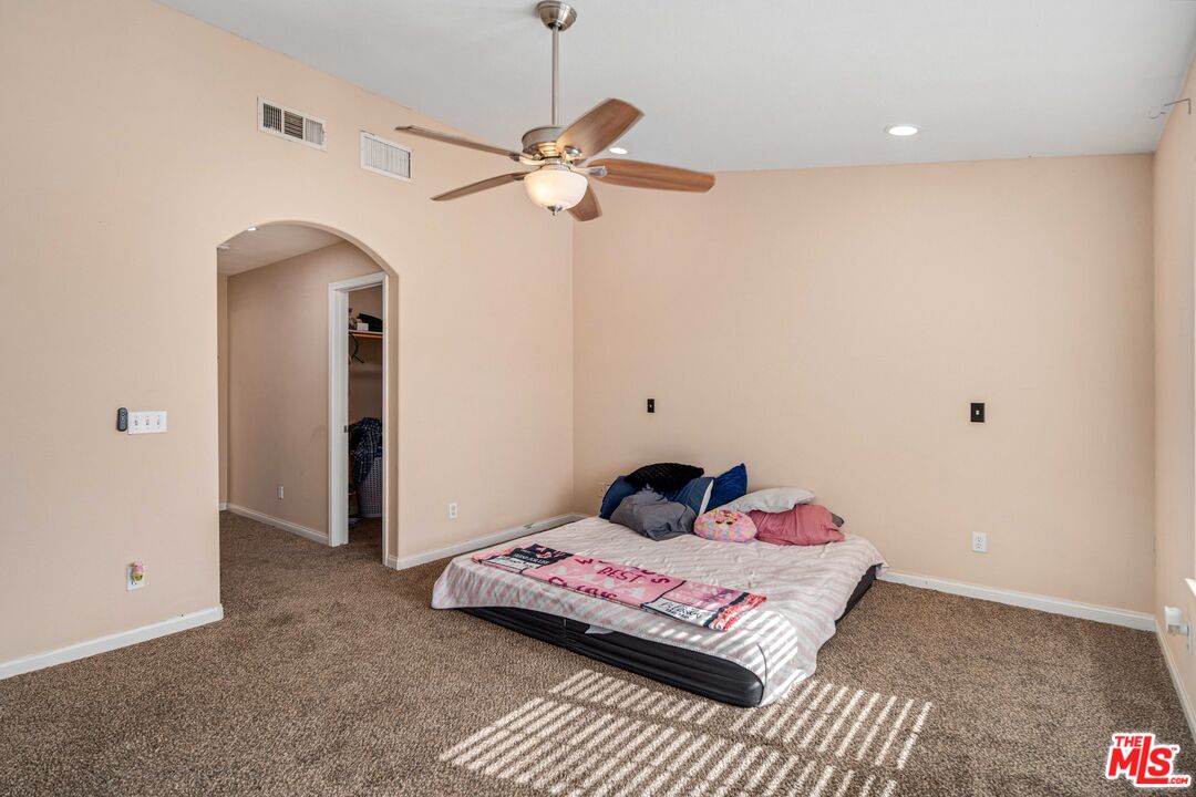 9516 Mendiburu Road California City, CA 93505 - Photo 18 of 32 a bedroom with a bed and wooden floor