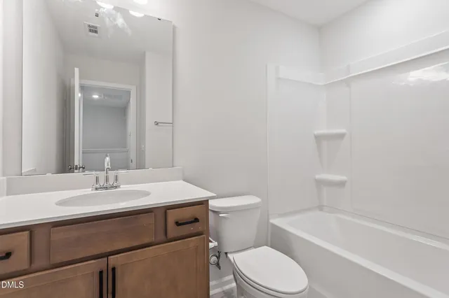 a view of a white house with a big yard and potted plants