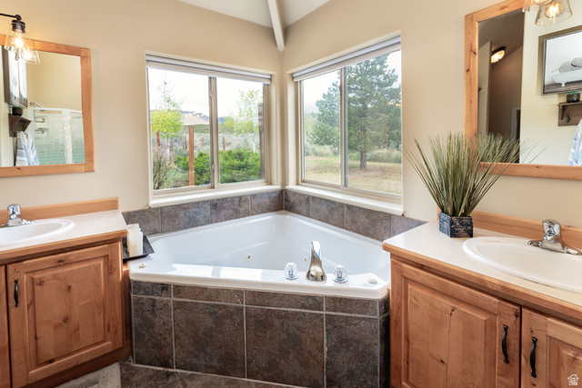 7343 North Sawtooth Cv Road Vernal, UT 84078 - Photo 19 of 64 Corner jetted tub set within tiled surround, featuring two large windows overlooking a natural landscape