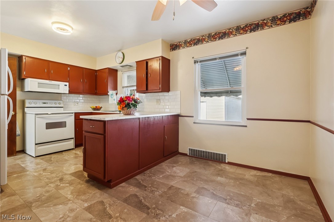 4252 Ridgeview Road Cleveland, OH 44144 - Photo 6 of 37 Kitchen featuring white appliances, light countertops, a peninsula, tasteful backsplash, and ceiling fan
