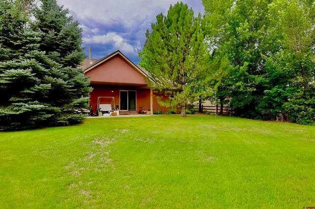 a view of house with backyard and garden