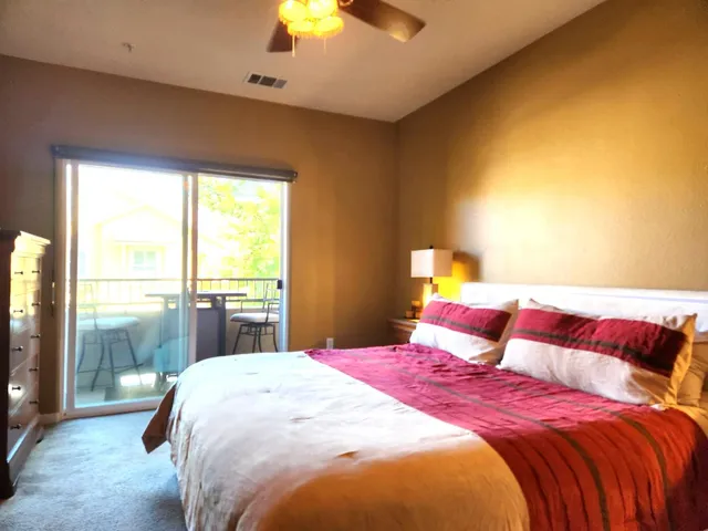 a bedroom with a bed and a lamp next to a window