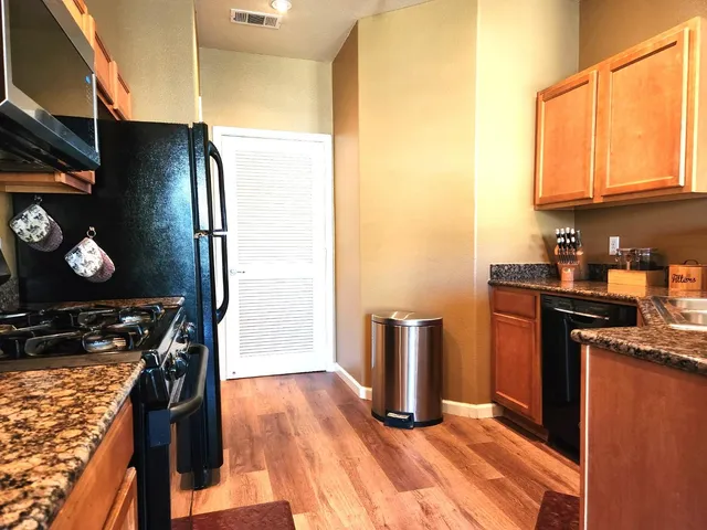a kitchen with stainless steel appliances granite countertop a refrigerator stove and sink