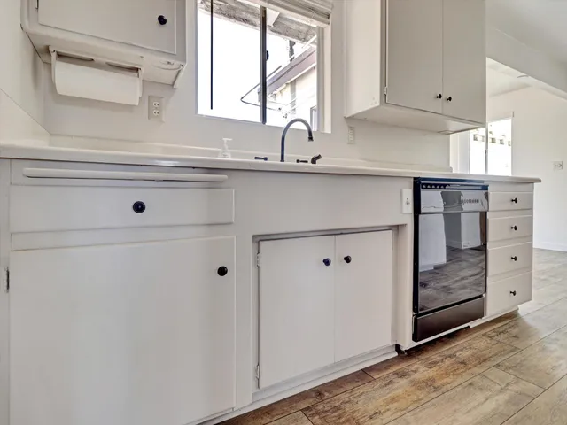 a kitchen with white cabinets and white appliances