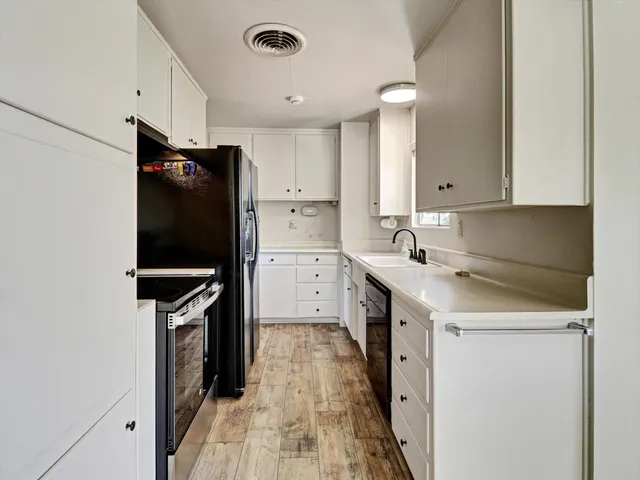 a kitchen with stainless steel appliances a stove refrigerator sink and cabinets