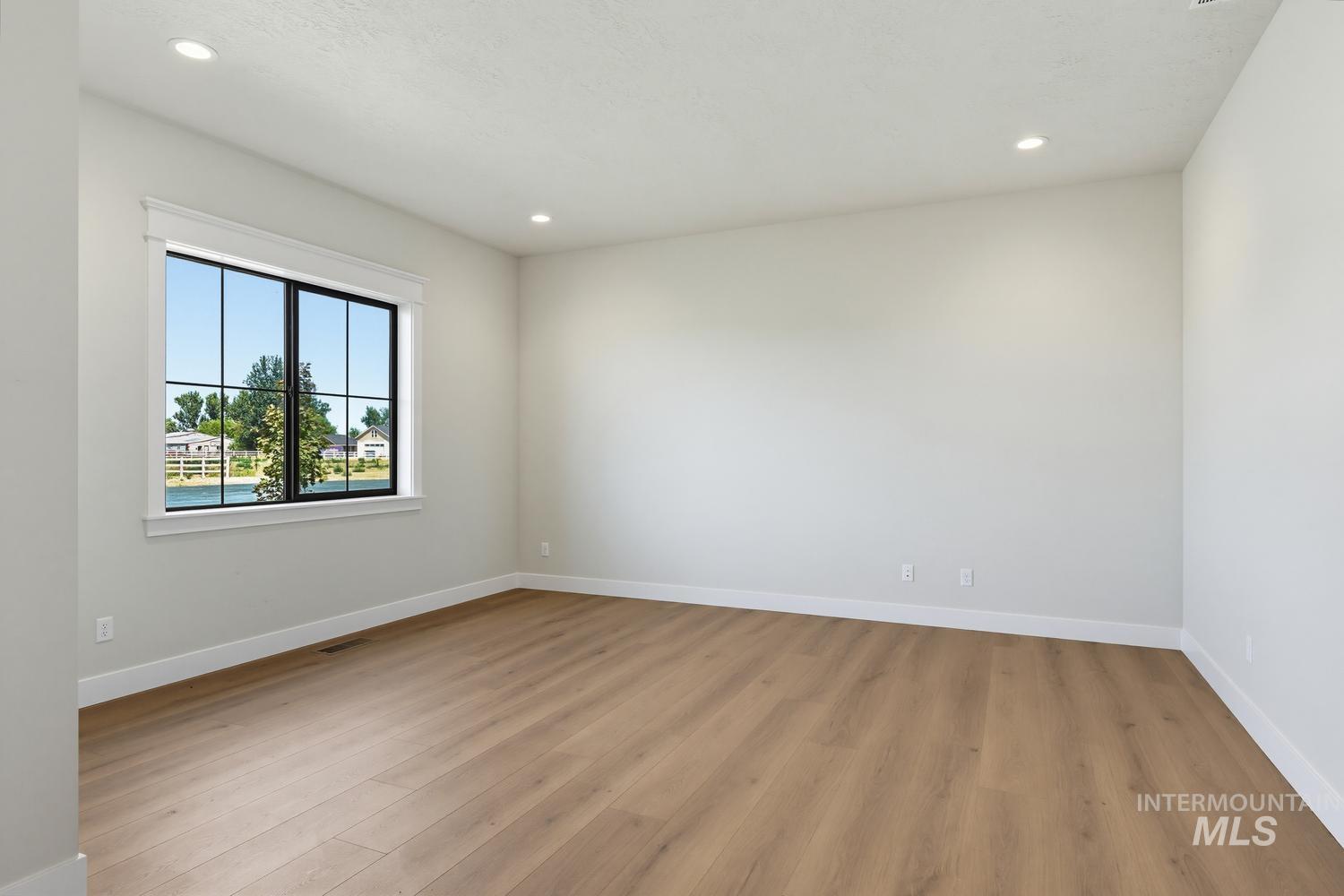 5054 Heritage Drive Marsing, ID 83639 - Photo 19 of 38 Bright interior space featuring a multi-pane window with black framing, wood-finish flooring, recessed lighting, white baseboards, and neutral wall tones