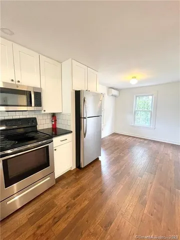 a kitchen with wooden floors and stainless steel appliances