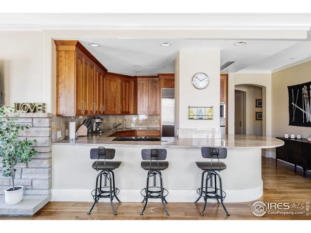 a kitchen with stainless steel appliances kitchen island granite countertop a table and chairs in it