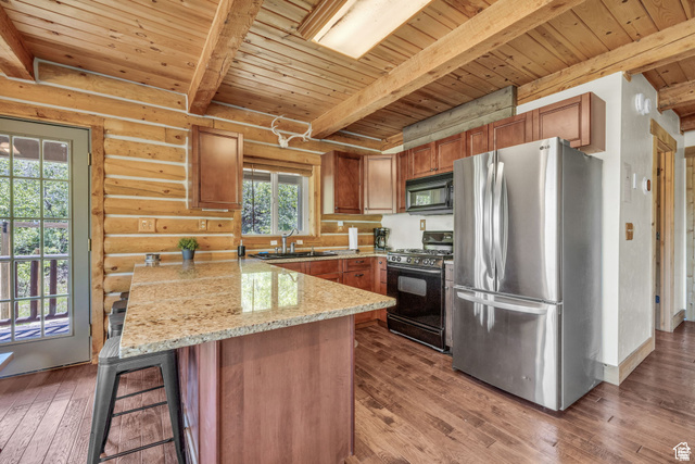 2348 North Miles Holw Road, Unit 26 Kamas, UT 84036 - Photo 8 of 31 Kitchen with black appliances, light stone counters, a wood ceiling with exposed beams, dark wood-style flooring, and a peninsula