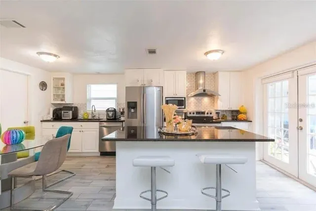 a kitchen with white cabinets and stainless steel appliances
