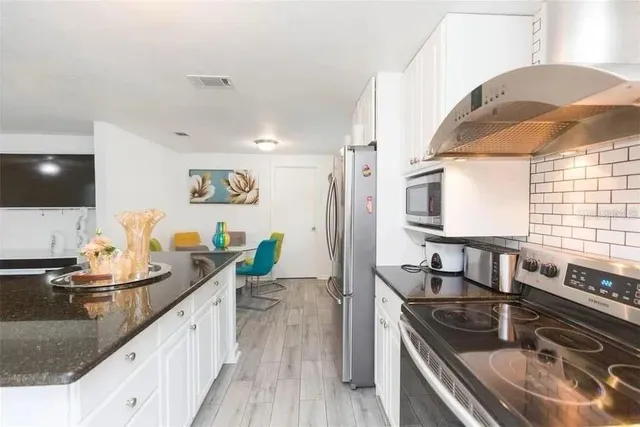 a kitchen with granite countertop a sink and a stove top oven