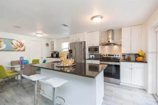 a kitchen with white cabinets and stainless steel appliances