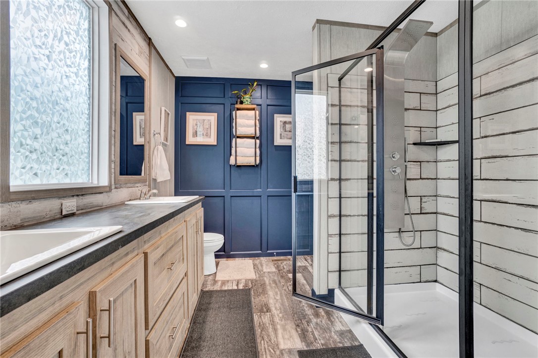 2655 State Rd S-4-108 Anderson, SC 29624 - Photo 16 of 37 Textured wood-grain flooring and a glass-enclosed shower highlight this modern primary bathroom.