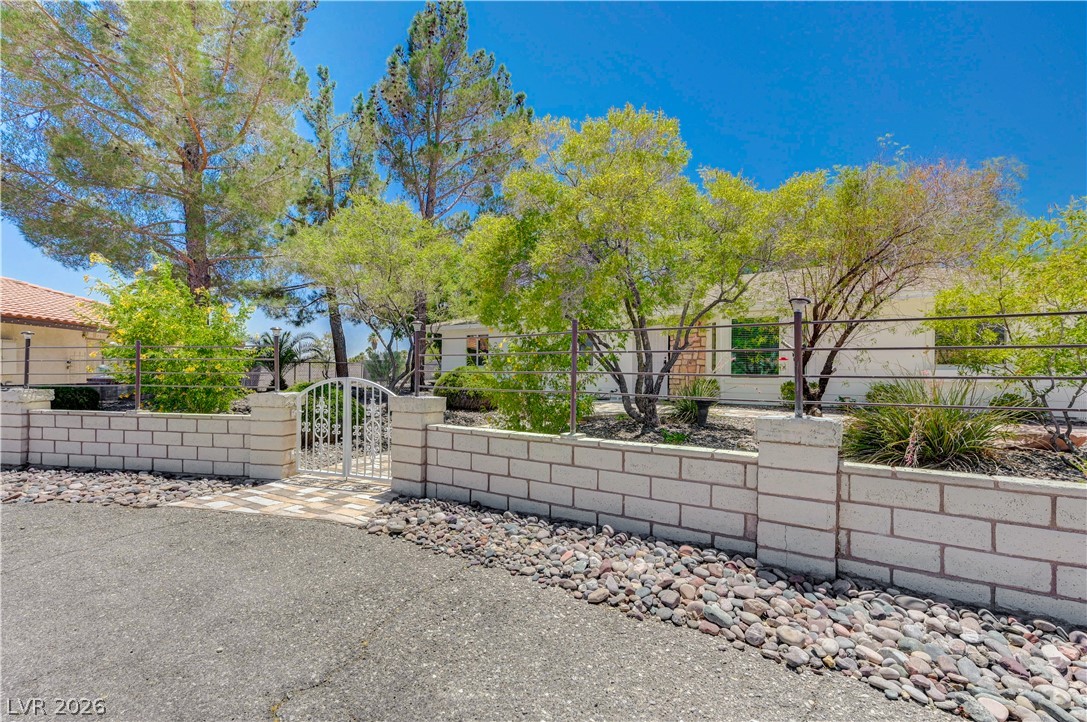 7631 Bermuda Road Las Vegas, NV 89123 - Photo 5 of 64 A charming gated entry with a decorative white iron gate welcomes visitors to this inviting residence.