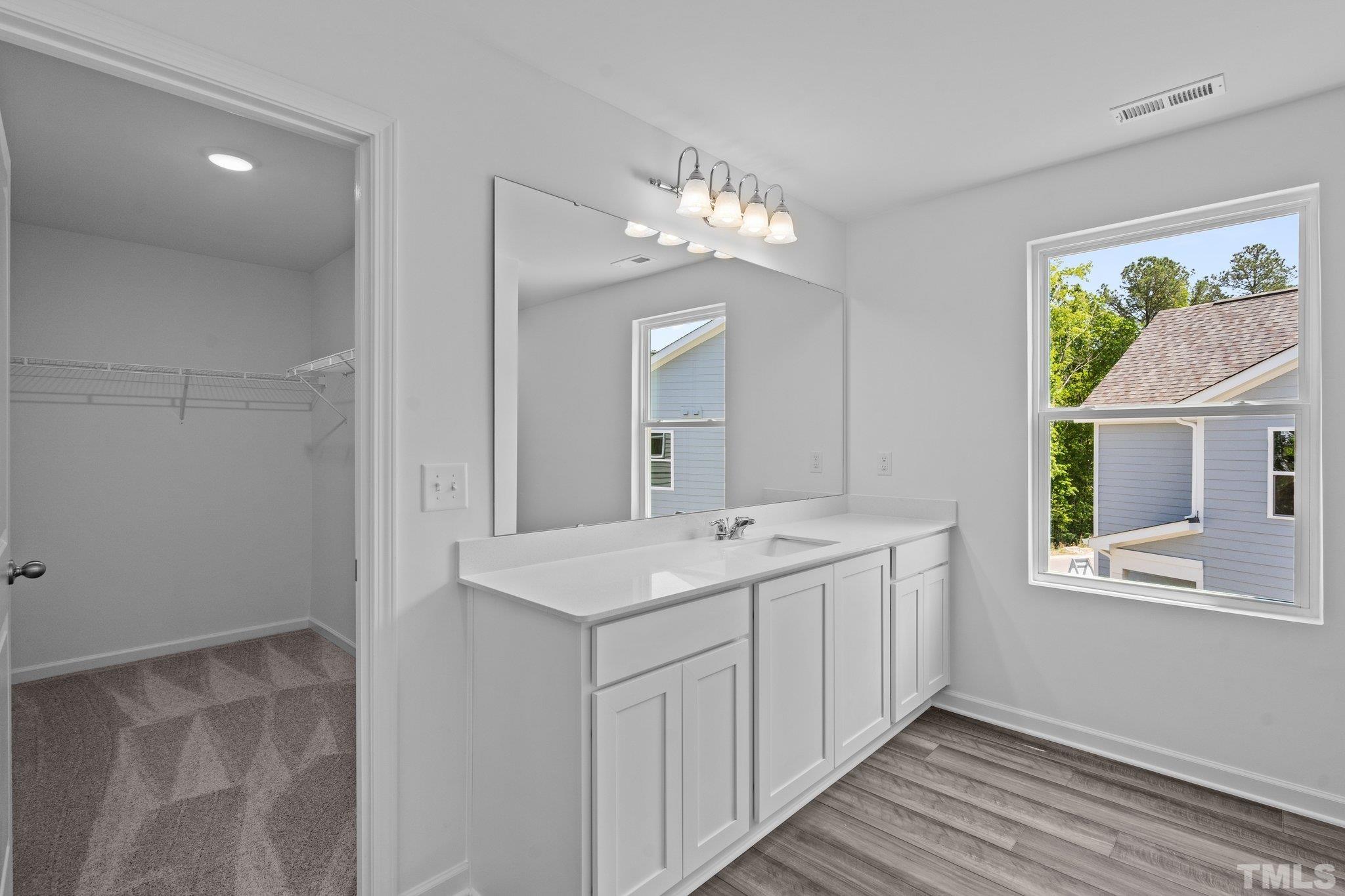 309 Spaight Acrs Way Wake Forest, NC 27587 - Photo 18 of 41 a spacious bathroom with a double vanity sink and a mirror