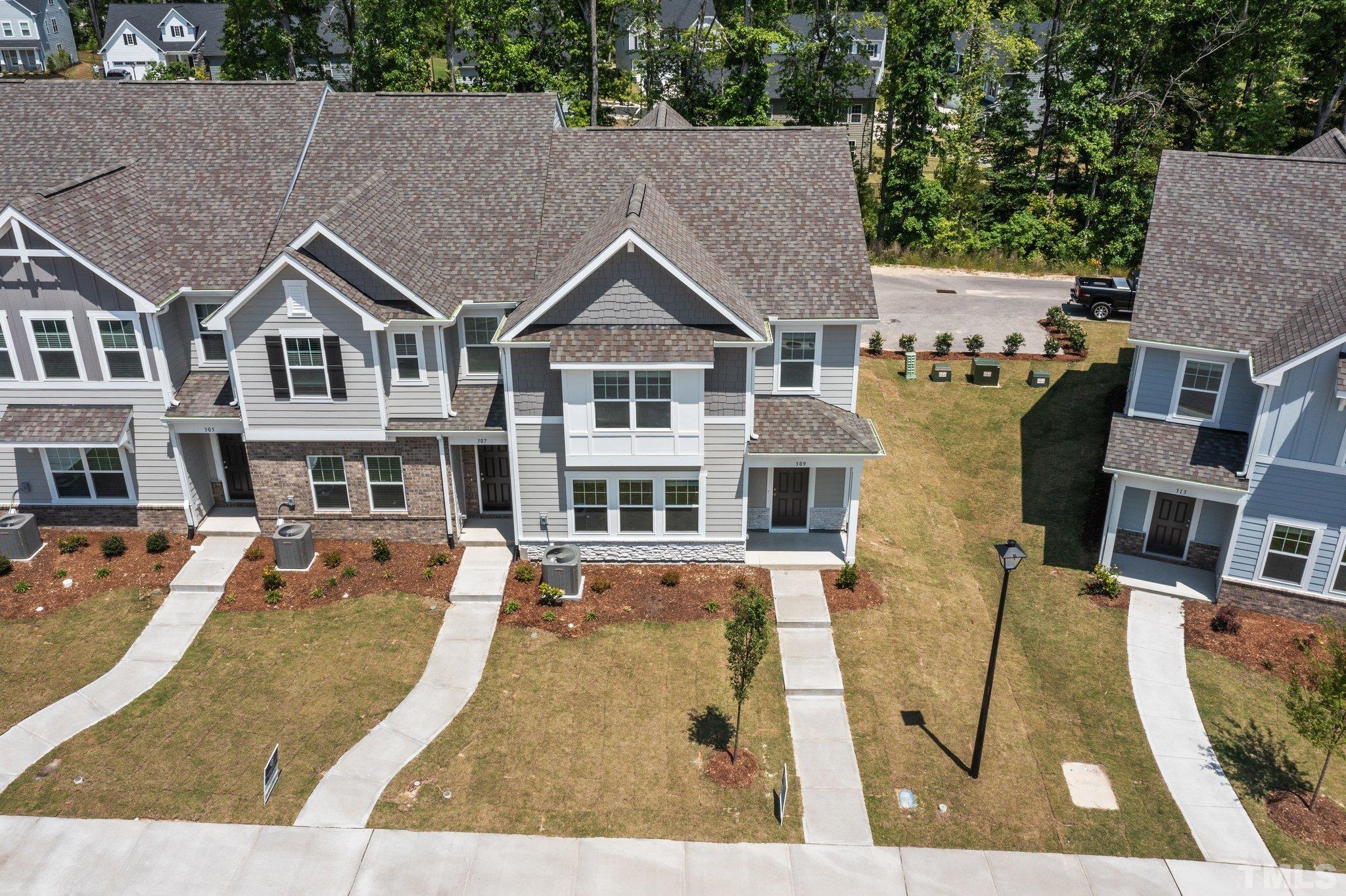 309 Spaight Acrs Way Wake Forest, NC 27587 - Photo 28 of 41 a view of a house with pool lawn chairs and large trees