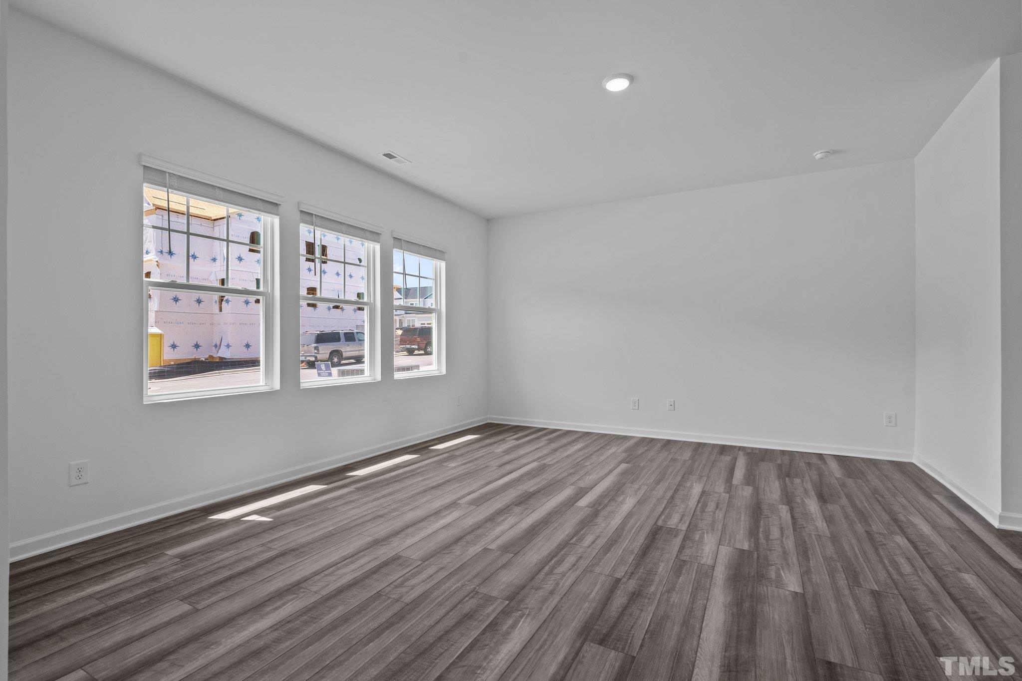 309 Spaight Acrs Way Wake Forest, NC 27587 - Photo 5 of 41 wooden floor in an empty room with a window
