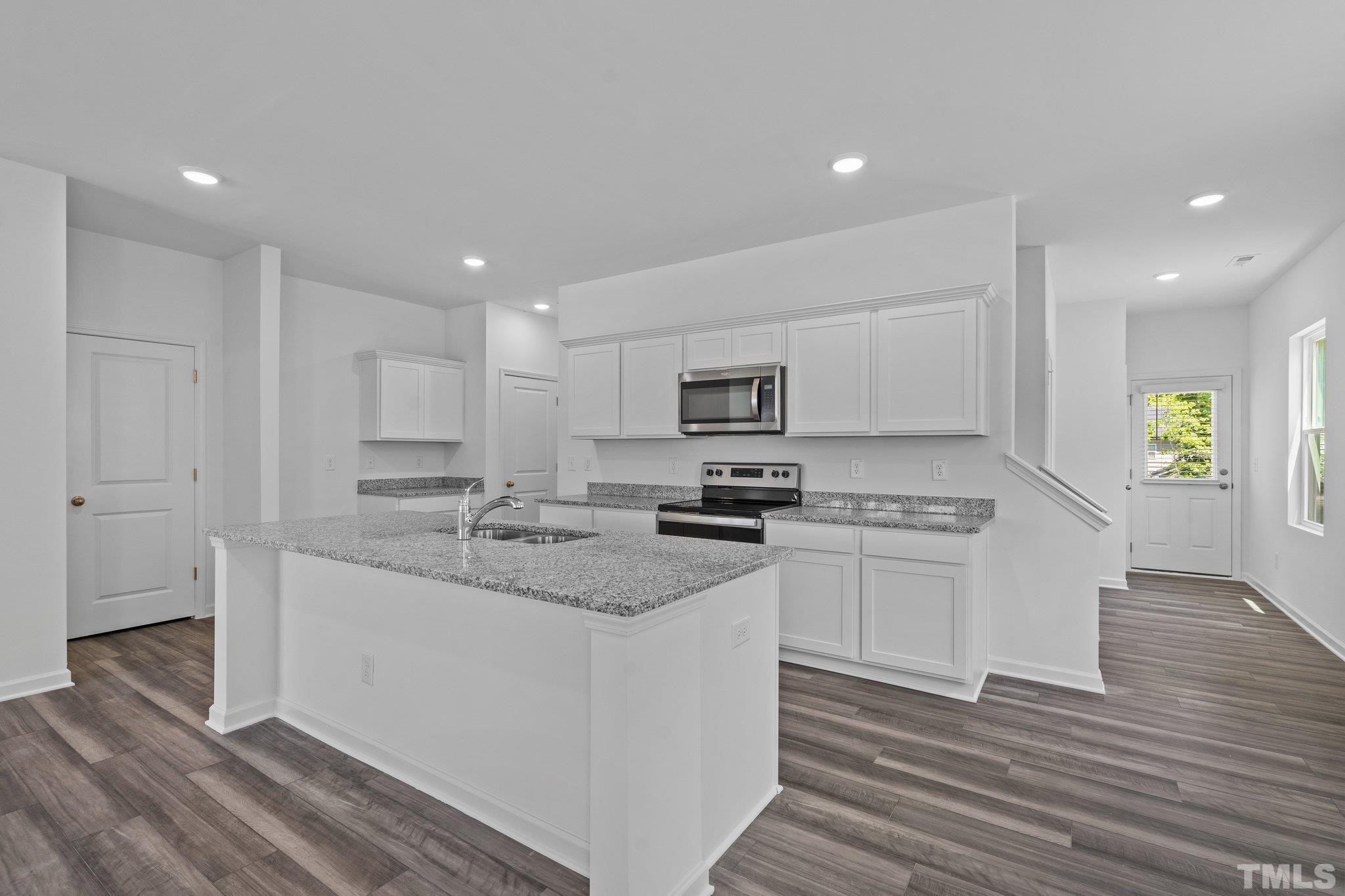 309 Spaight Acrs Way Wake Forest, NC 27587 - Photo 7 of 41 a kitchen with stainless steel appliances granite countertop a sink a stove a refrigerator and white cabinets with wooden floor