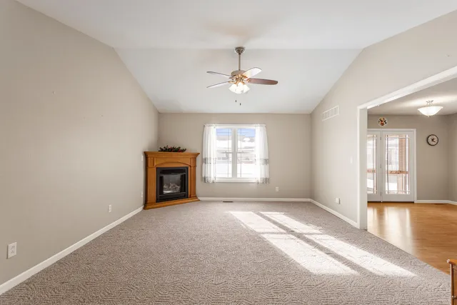 a view of an empty room with a window and fireplace