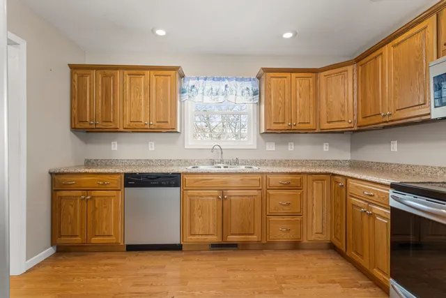 a kitchen with stainless steel appliances granite countertop a stove a sink and a microwave
