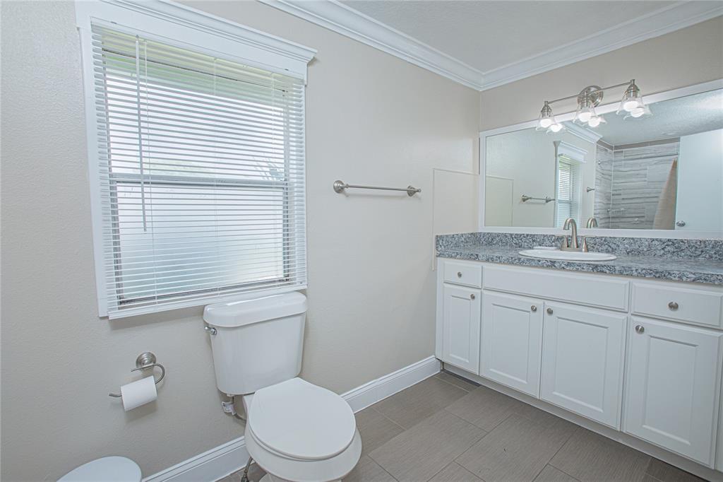 2009 Pine Street St. Cloud, FL 34769 - Photo 6 of 17 a bathroom with a granite countertop sink vanity mirror and toilet