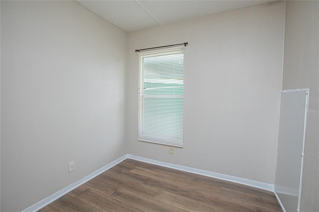 2009 Pine Street St. Cloud, FL 34769 - Photo 8 of 17 a view of an empty room with wooden floor and a window