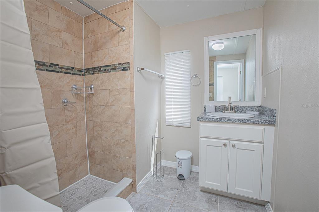 2009 Pine Street St. Cloud, FL 34769 - Photo 9 of 17 a bathroom with a granite countertop sink toilet and shower
