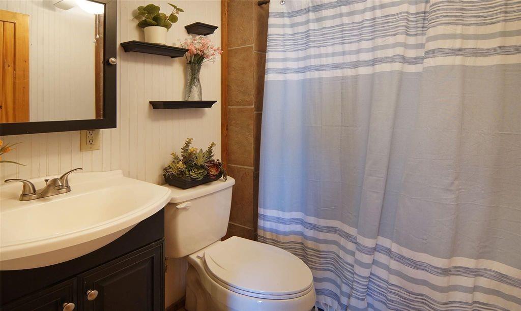 504 Doe Lane Graham, TX 76450 - Photo 11 of 27 a bathroom with a sink a toilet and shower curtain