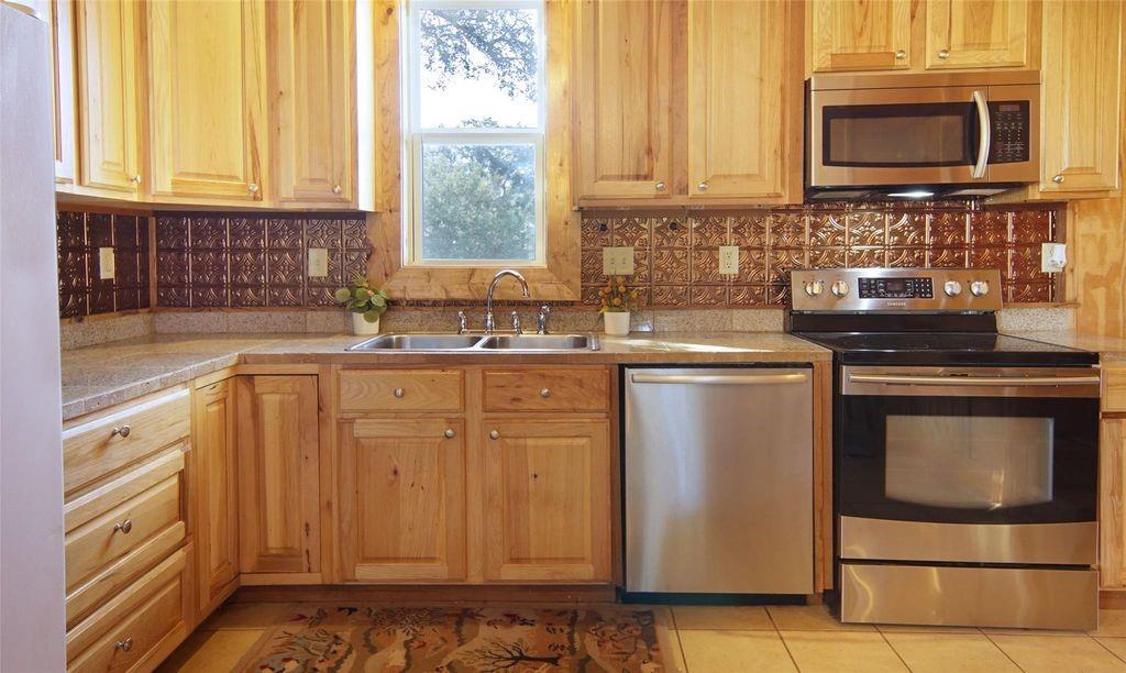 504 Doe Lane Graham, TX 76450 - Photo 5 of 27 a kitchen with granite countertop a sink stove and microwave