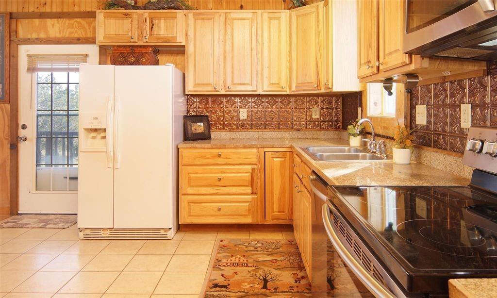 504 Doe Lane Graham, TX 76450 - Photo 6 of 27 a kitchen with stainless steel appliances a sink a counter and cabinets