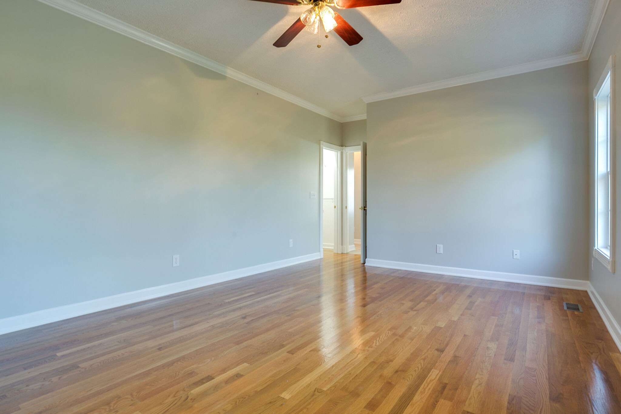 163 Harper Road Manchester, TN 37355 - Photo 27 of 43 an empty room with wooden floor chandelier fan and windows