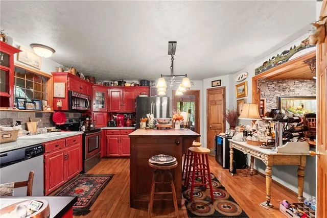 a kitchen with a refrigerator a stove a sink and a dining table with chairs