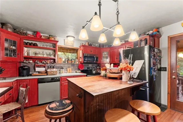 a kitchen with stainless steel appliances a stove a sink dishwasher and cabinets with wooden floor