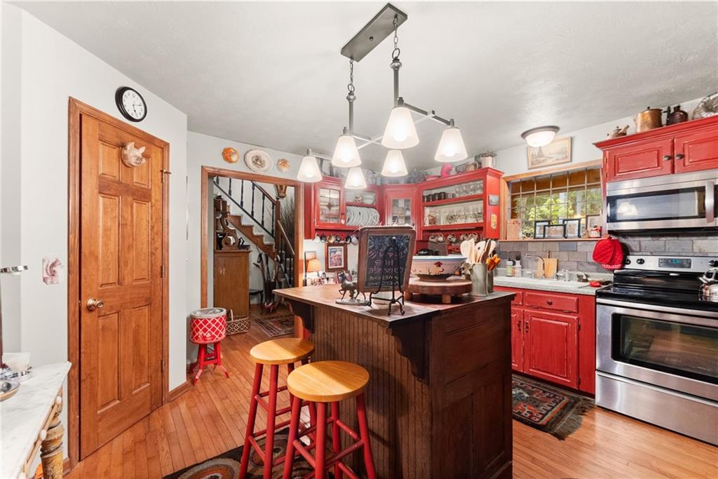 62 High Ridge Road Cleveland, GA 30528 - Photo 15 of 55 a kitchen with stainless steel appliances a stove a sink dishwasher and cabinets with wooden floor