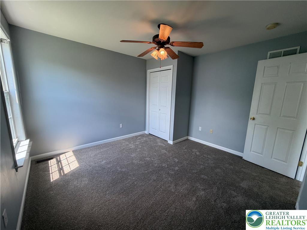 4157 Walter Road Bethlehem, PA 18020 - Photo 24 of 36 A well-lit bedroom features plush carpet and a classic ceiling fan, perfect for unwinding.