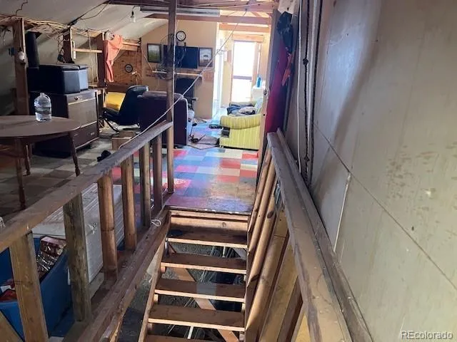 a view of a room with wooden floor and iron stairs